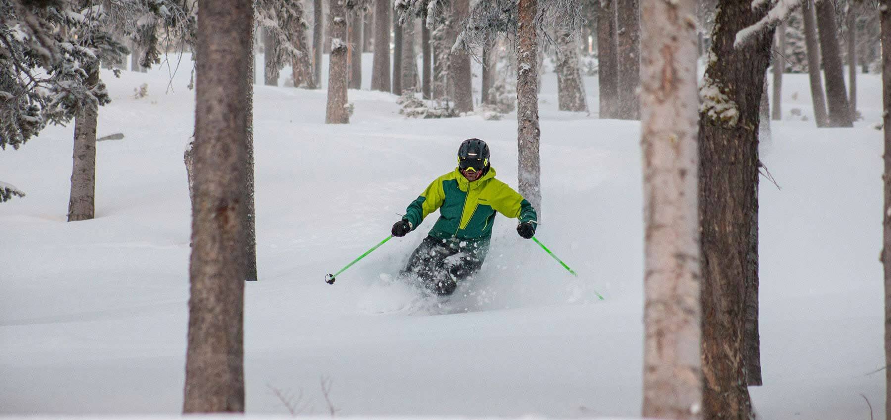 man skiing powder in the trees at red lodge mountain