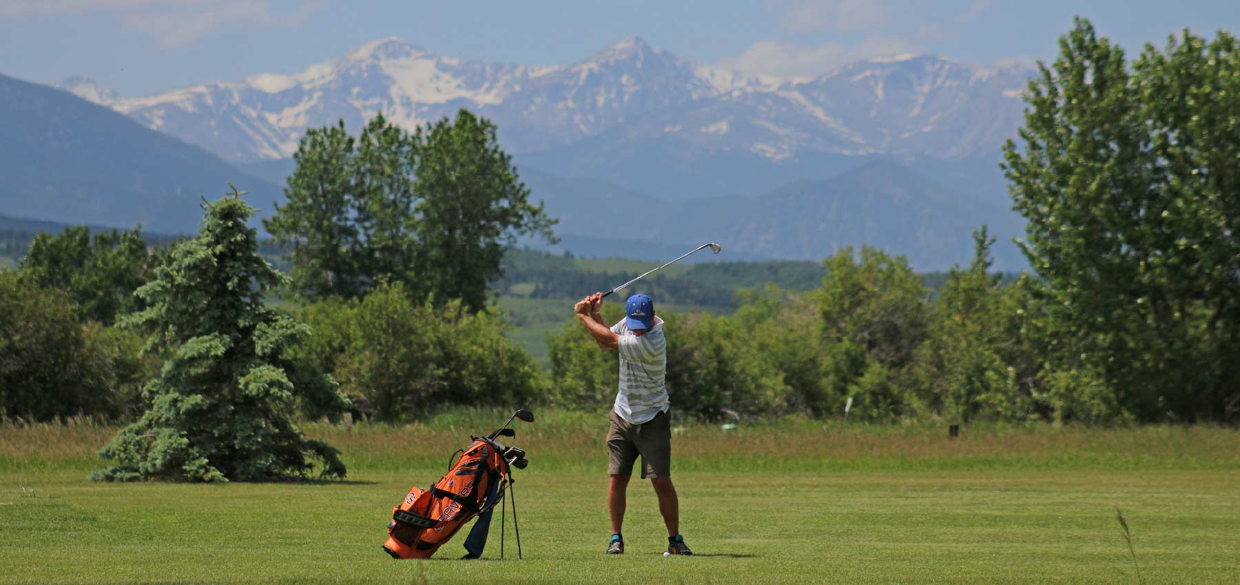 man golfing with mountain views