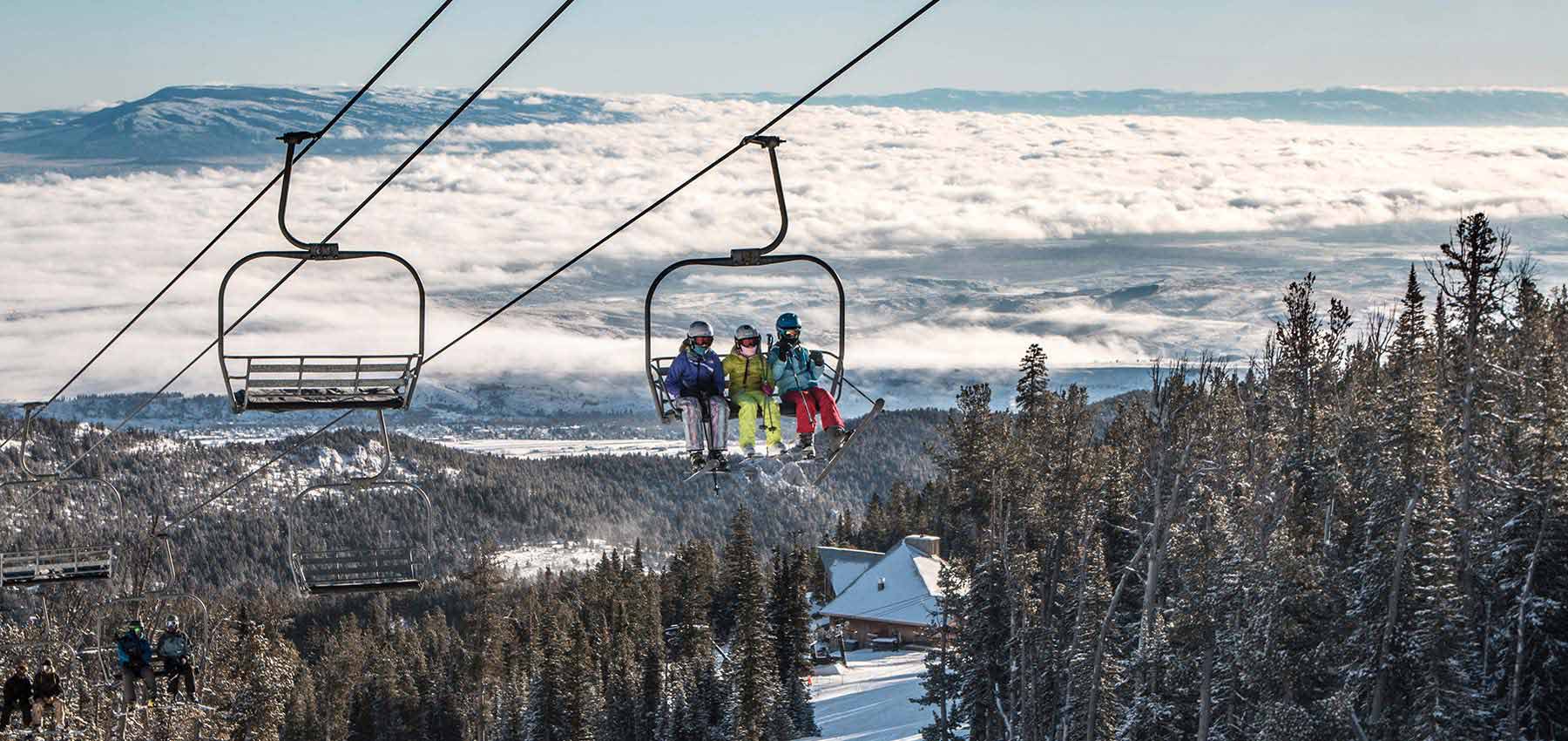 three kids riding the triple chairlift